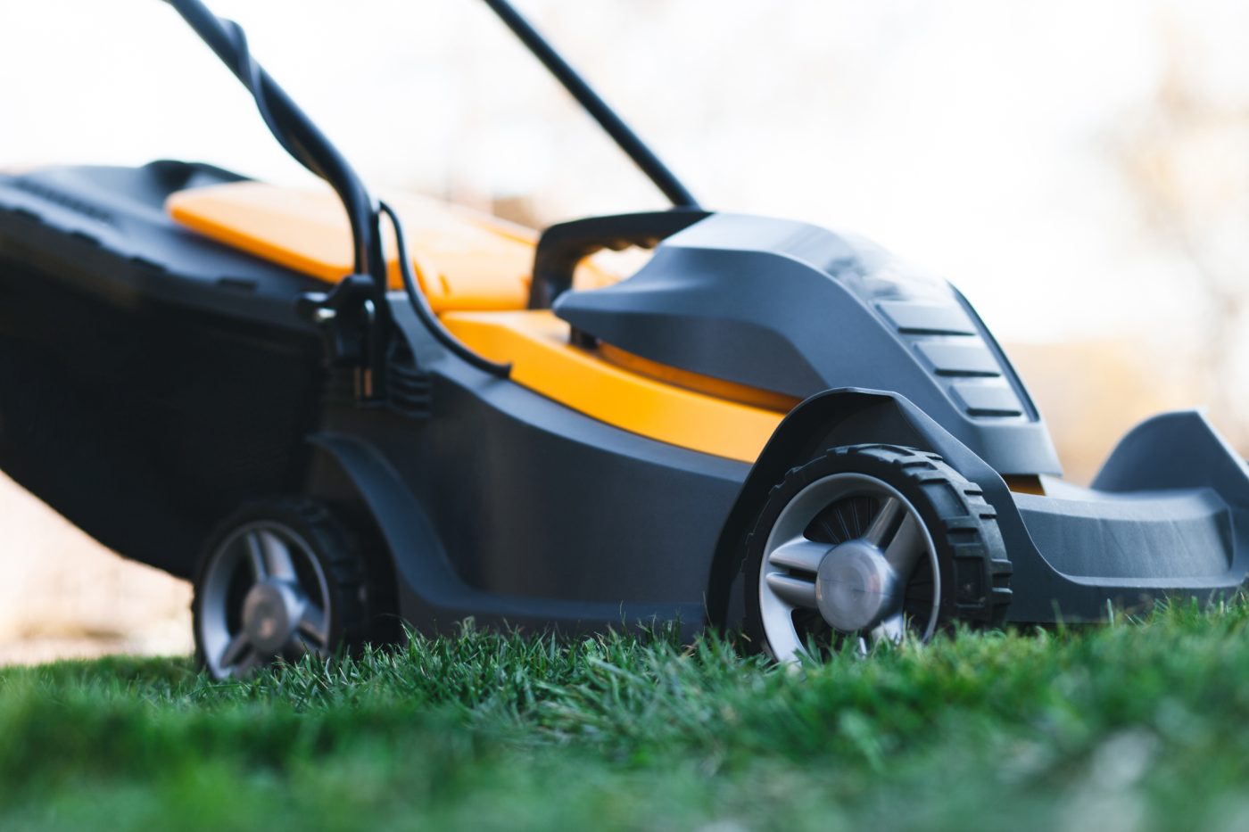 Electric lawn mower on a lawn at the garden. 